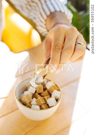 Top view of sugar being added to the coffee 56955102