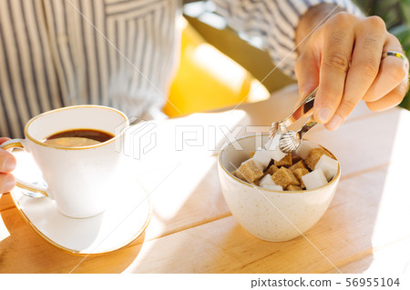 Close up of a piece of sugar being taken 56955104