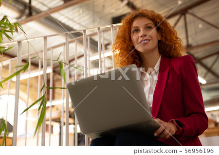 Woman wearing smart watch having inspiration while working 56956196