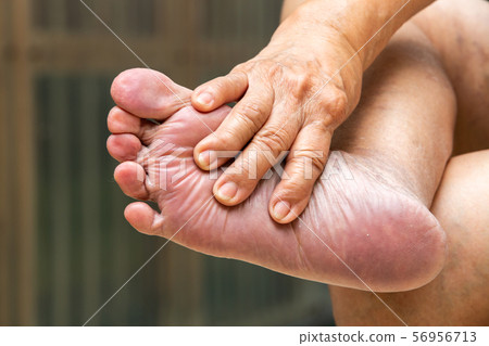 Senior woman's hands massaging her foot, About massage concept, Close up shot Senior woman's hands massaging her foot, About massage concept, Close up shot 56956713