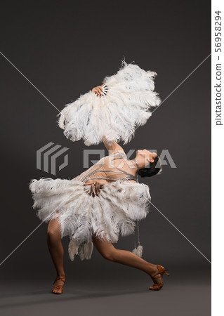 Girl dancing with white fan full-length shot Girl dancing with white fan full-length shot 56958294