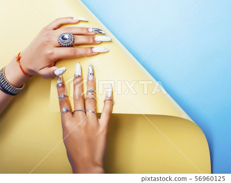 woman hands holding colorful paper copyspace wearing a lot of jewelry and long nails closeup woman hands holding colorful paper copyspace wearing a lot of jewelry and long nails closeup 56960125
