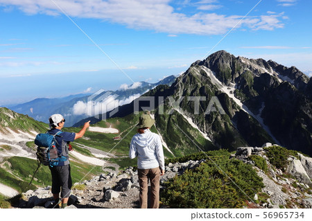 徒步旅行者指著山。 徒步旅行者指著山。 56965734