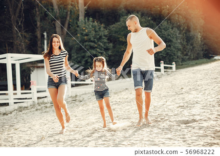 Family with daughter playing on a sand 56968222