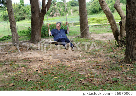 old mature elderly senior woman sitting on swing old mature elderly senior woman sitting on swing 56970003