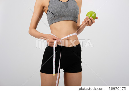 sporty fitness woman in sportswear with measuring waist with tape. healthy sport lifestyle 56970475