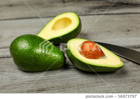 Two Avocados One Cut In Half Seed Visible Knife Stock Photo