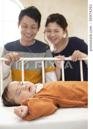 一對夫婦看著一個嬰兒 56974262