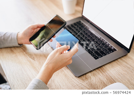 Asian woman holding credit card paying for Asian woman holding credit card paying for 56974424