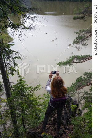 Girl  on a mountain lake 56976419