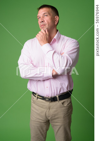 Portrait of mature macho businessman thinking and looking up 56976944