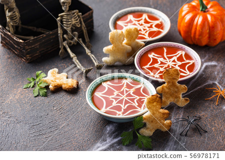 Tomato soup and bread in shape of men. 56978171