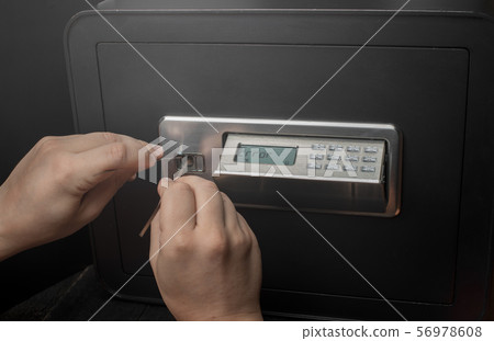 Close-up of Thief's hands breaking money safe 56978608