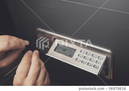 Close-up of Thief's hands breaking money safe 56978616