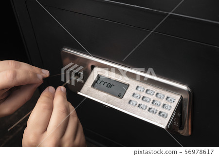 Close-up of Thief's hands breaking money safe Close-up of Thief's hands breaking money safe 56978617