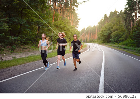 A group of three people athletes one girl and two 56980122
