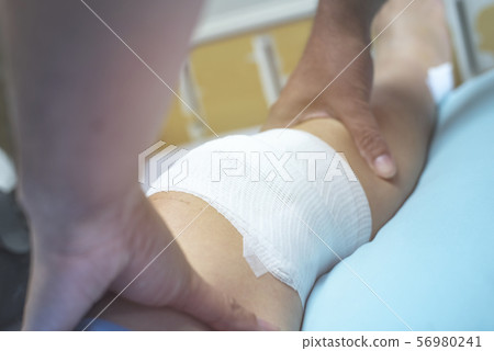 Hand of doctor touch on leg of patient after do 56980241