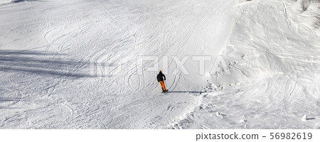 Skier on ski slope at sun winter day Skier on ski slope at sun winter day 56982619