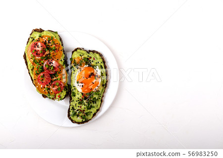 Sandwiches with avocado guacomole, egg and tomatoes, green leek and sesame seeds. Healthy breakfast Sandwiches with avocado guacomole, egg and tomatoes, green leek and sesame seeds. Healthy breakfast 56983250