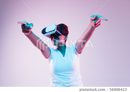 Young african-american woman's using VR-glasses in neon light 56986423