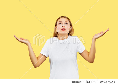 Caucasian young woman's half-length portrait on yellow background 56987023
