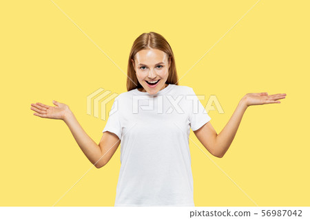 Caucasian young woman's half-length portrait on yellow background Caucasian young woman's half-length portrait on yellow background 56987042