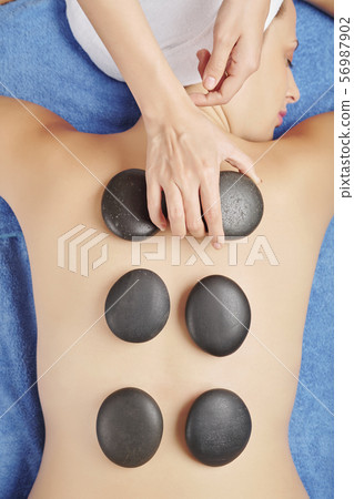Massage with heated rocks Massage with heated rocks 56987902