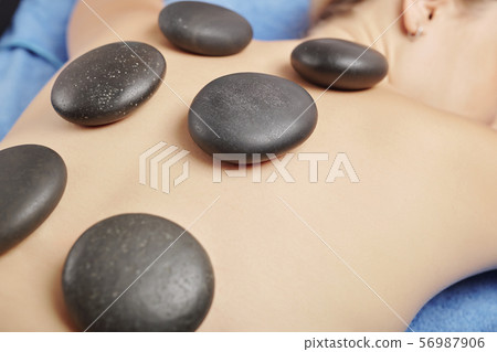 Heated basalt stones on back Heated basalt stones on back 56987906