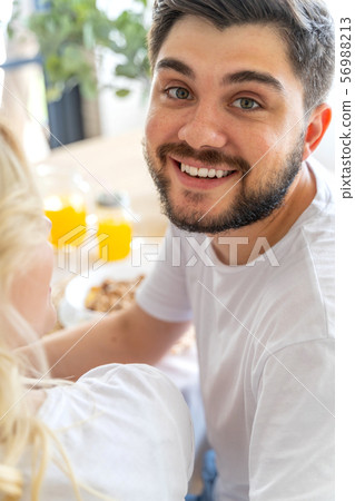 Happy man is having breakfast at home 56988213