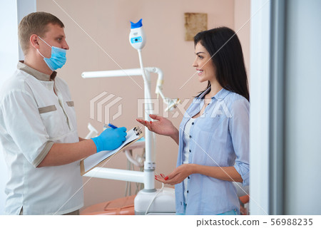 Male stomatologist and cheerful woman are discussing Male stomatologist and cheerful woman are discussing 56988235