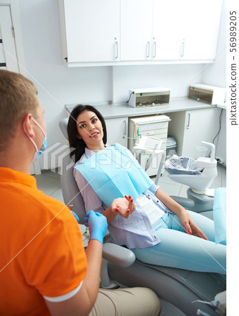 Pretty lady speaking with dentist in clinic Pretty lady speaking with dentist in clinic 56989205