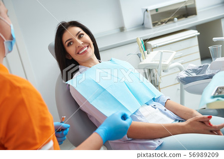 Smiling lady receiving teeth treatment in dental clinic Smiling lady receiving teeth treatment in dental clinic 56989209