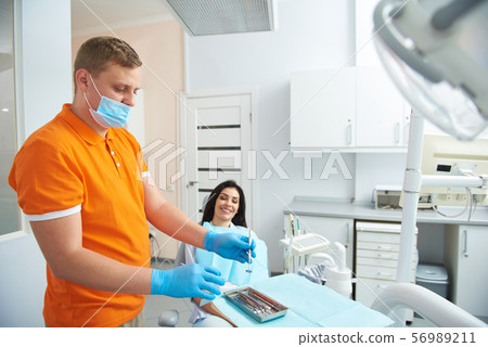 Stomatologist is preparing instruments for treatment teeth 56989211