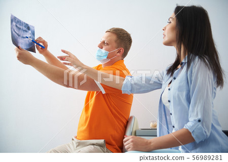 Stomatologist discussing results of orthopantomogram to lady 56989281