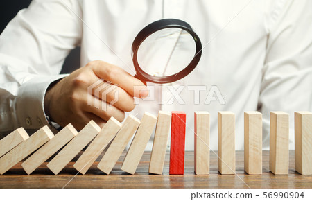 Businessman looks on collapse domino effect. 56990904
