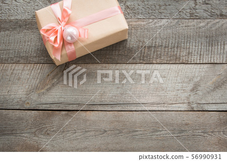 Handmade present from wrapping paper and pink bow 56990931