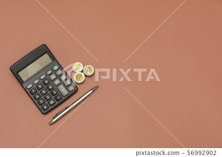 Stack of coin and calculator with copy space. 56992902