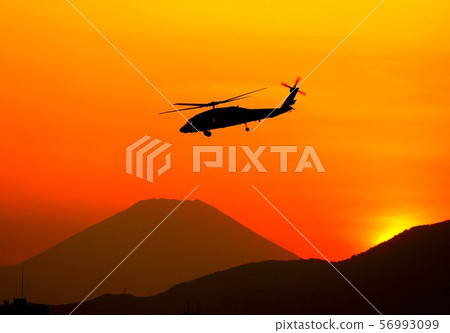 US Navy aircraft carrier SH-60F Ocean Hawk anti-submarine patrol helicopter flying against Mt. Fuji floating in a beautiful sunset 56993099