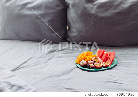 Plate with tropical fruit in grey bed, pilow 56994956