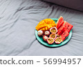 Plate with tropical fruit in grey bed, breakfast 56994957