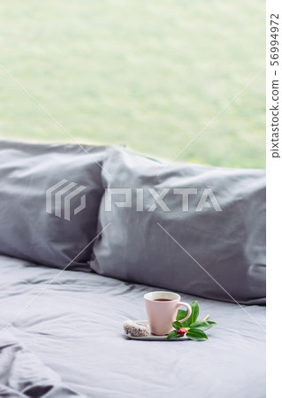 grey Bed next to window, coffee, donut, flower 56994972