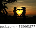 Silhouette of the hearts of girls and the sunset sky over the sea 56995877
