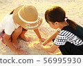 Girls playing in the sand 56995930