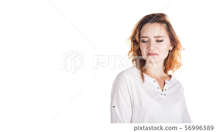 disgusted and frowning young woman on a white background disgusted and frowning young woman on a white background 56996389