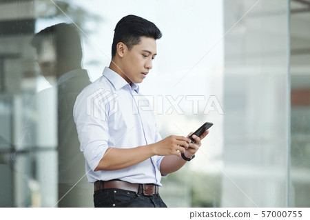 Young entrepreneur checking phone Young entrepreneur checking phone 57000755