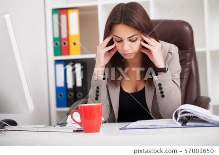 Headache and Stress at Work. Portrait of Young Business Woman at her office 57001650