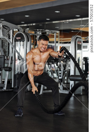 Man exercising with battle rope Man exercising with battle rope 57001652