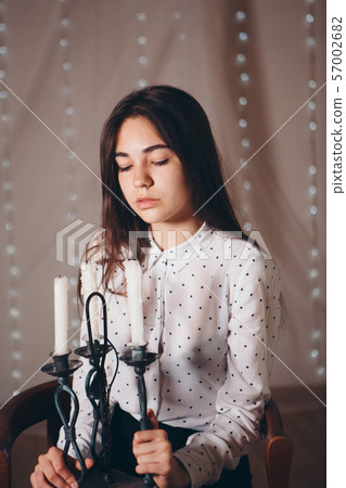 portrait of a girl with a candle. Concept of religious holidays, alternative lighting 57002682