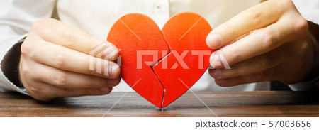 A man collects a broken heart in his hands. A man collects a broken heart in his hands. 57003656