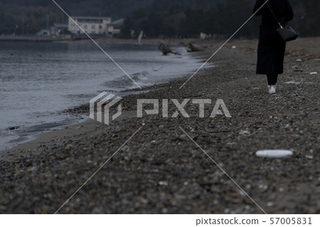 A woman walking on the beach A woman walking on the beach 57005831